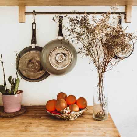 two gray frying pans hanging on wall